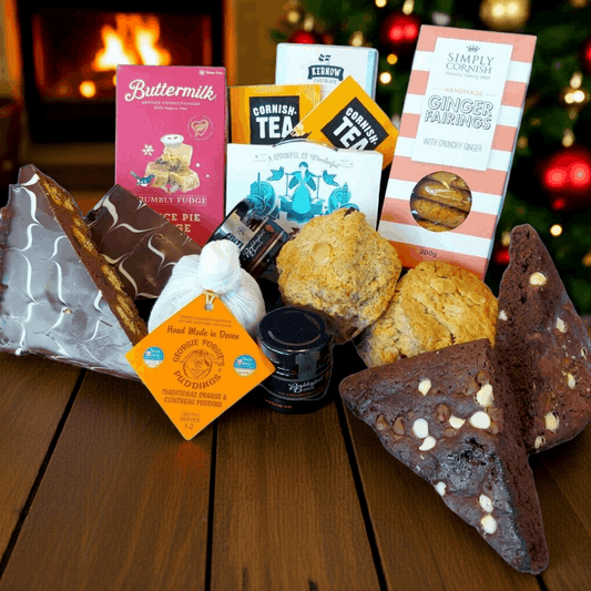 Assorted baked goods and tea packages on a wooden surface with a festive background.