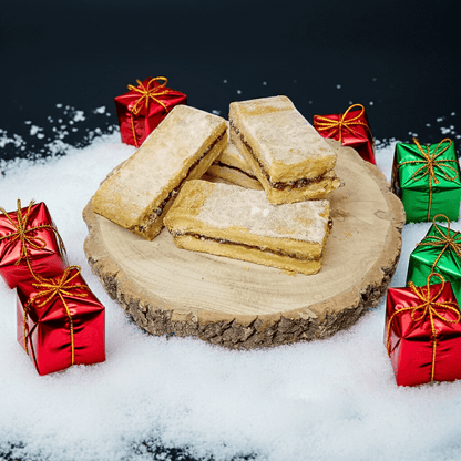 Shortbread cookies on a wooden board with Christmas presents in the background