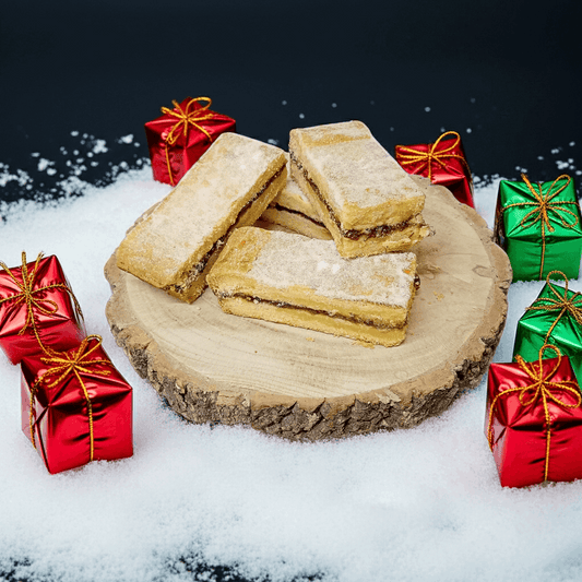 Shortbread cookies on a wooden board with Christmas presents in the background
