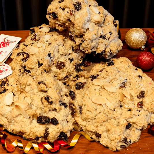Baked goods with raisins and almonds on a wooden surface with festive decorations.